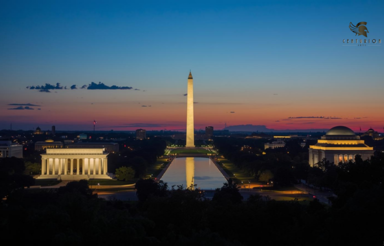 Washington D.C. at dusk, showcasing the illuminated monuments and buildings against a deep blue sky with subtle orange and pink hues near the horizon. Charter a private jet to Washington D.C. with Centurion Jets. Access DCA, IAD & Dulles FBOs, 10,000+ aircraft, 24/7 concierge. Lobbyists, executives & diplomats fly private with us.